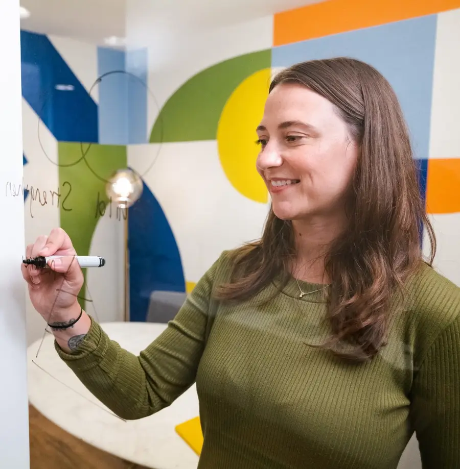 People looking at and pointing at post-it notes on window.