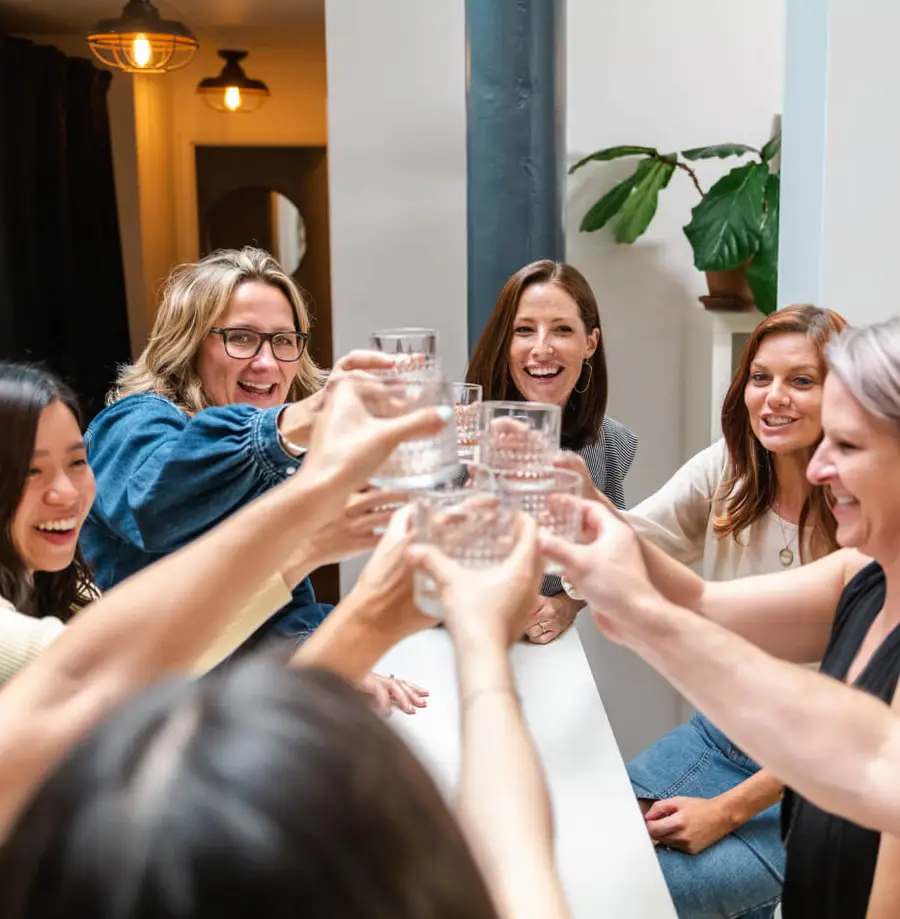 People celebrating holding up cups, saying cheers